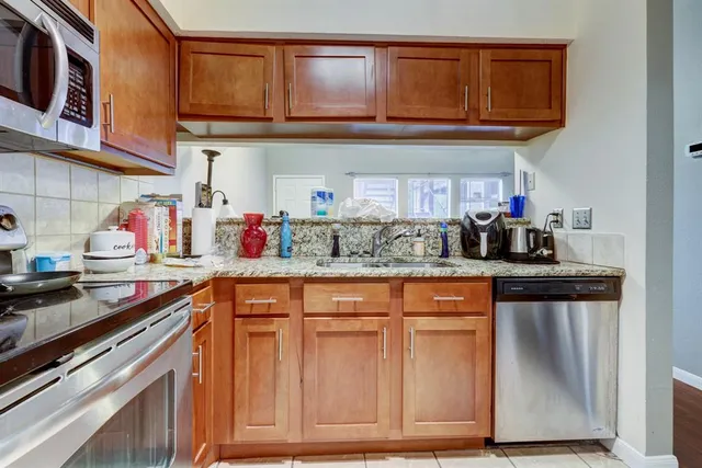 a kitchen with stainless steel appliances granite countertop a sink and cabinets