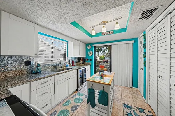 a kitchen with stainless steel appliances granite countertop a sink and a refrigerator