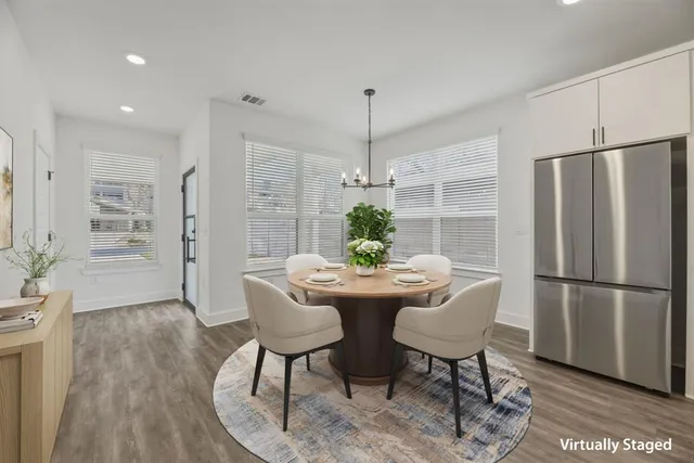 a living room with furniture kitchen view and a wooden floor