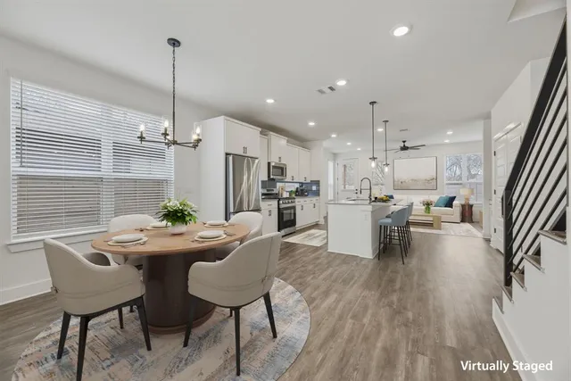 a kitchen with stainless steel appliances kitchen island granite countertop a dining table chairs and couches
