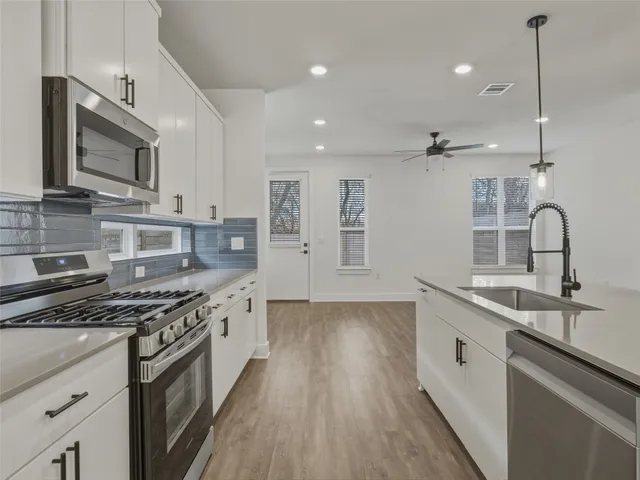 a view of a kitchen with a refrigerator and a microwave