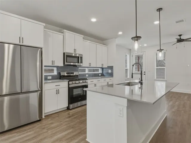 a view of a kitchen with furniture and wooden floor