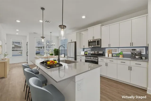 a kitchen with stainless steel appliances granite countertop a sink a stove and a refrigerator