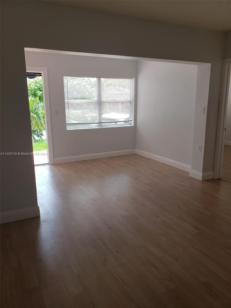 2940 Southwest 38th Court, Unit 2942 Miami, FL 33134 - Photo 3 of 10 a view of an empty room with wooden floor and a window