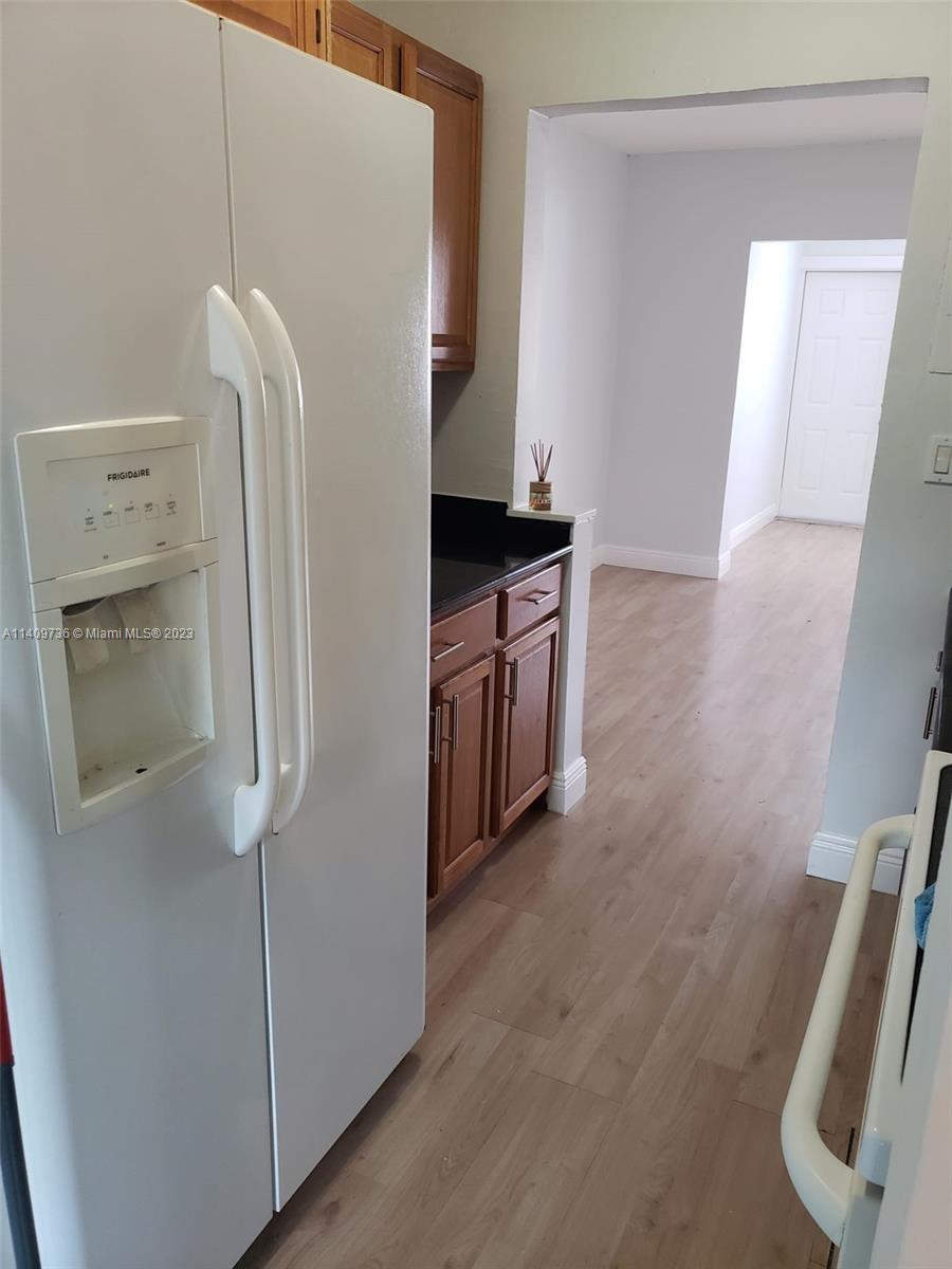 2940 Southwest 38th Court, Unit 2942 Miami, FL 33134 - Photo 4 of 10 a kitchen with a refrigerator and a sink