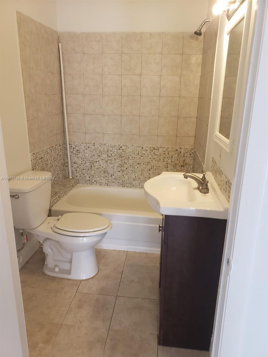 2940 Southwest 38th Court, Unit 2942 Miami, FL 33134 - Photo 7 of 10 a bathroom with a sink a toilet and a mirror