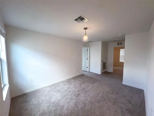an empty room with closet and windows