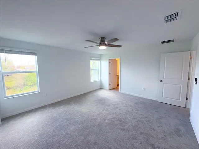 an empty room with a window and a ceiling fan