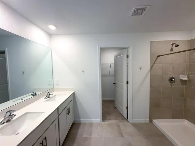 a spacious bathroom with a double vanity sink toilet and shower