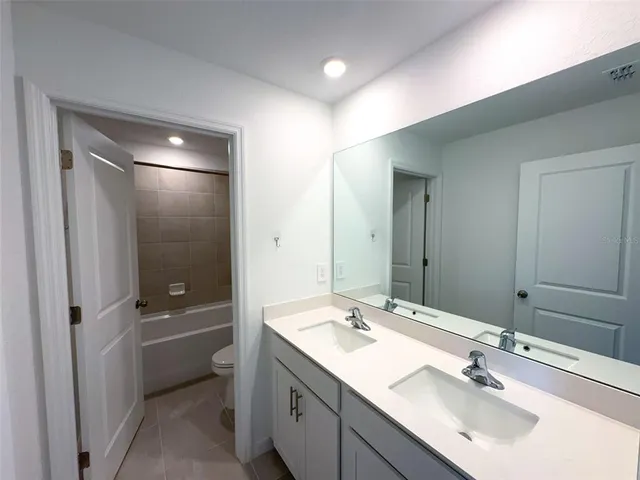a bathroom with a sink double vanity granite tub and shower