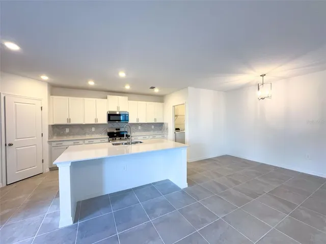 a large white kitchen with a stove a sink and a refrigerator