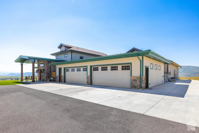 6117 North Rocky Ridge Road Peoa, UT 84061 - Photo 9 of 83 View of front of house featuring a garage and a mountain view