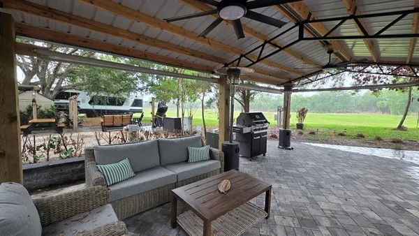 a living room with patio furniture and a garden