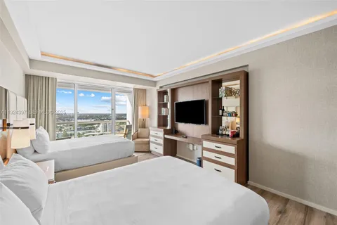 a bedroom with a bed and a large window