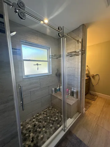 a bathroom with a glass door shower and a sink