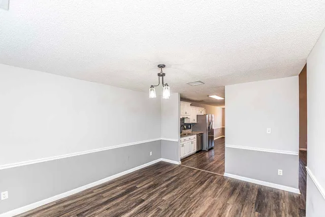 a view of a room with wooden floor and a ceiling fan