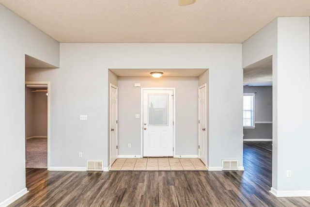 wooden floor in a hall with an entryway of a room