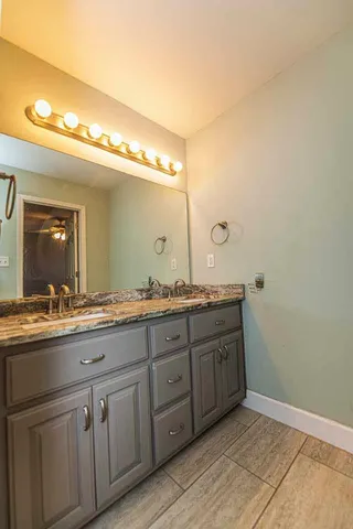 a bathroom with double sink and a mirror