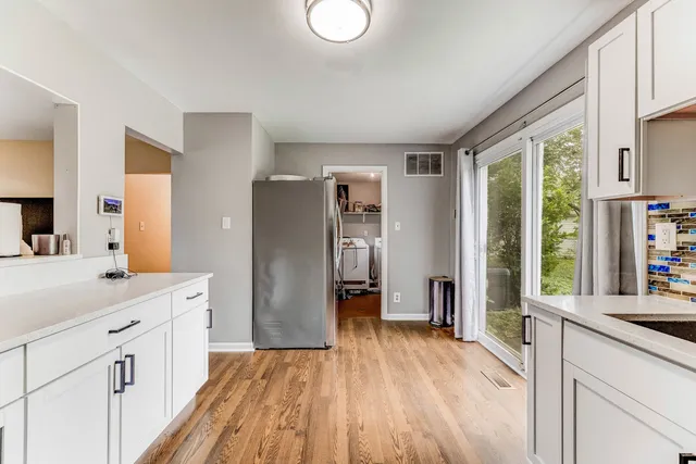 a kitchen with stainless steel appliances a refrigerator sink and wooden floor
