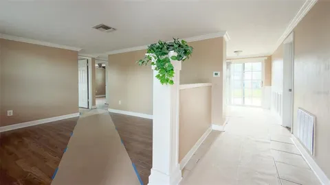 a view of a big room with wooden floor and a ceiling fan