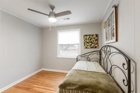 a view of a bedroom with window and ceiling fan