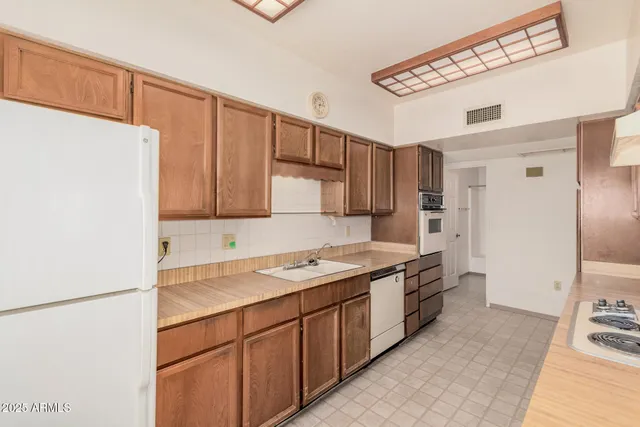 a kitchen with a sink a refrigerator and cabinets