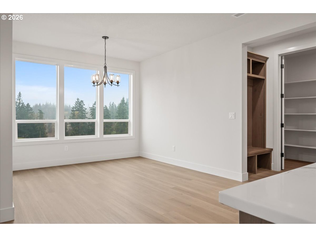 3509 North 11th Circle Ridgefield, WA 98642 - Photo 19 of 43 a view of an empty room with wooden floor kitchen view and a window