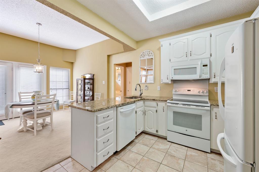 1828 Realistic Court Bedford, TX 76021 - Photo 8 of 16 a kitchen with white cabinets and white appliances