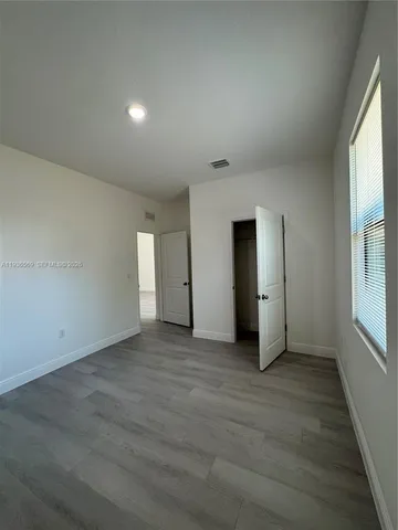 an empty room with windows and closet
