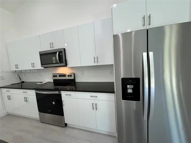 a kitchen with stainless steel appliances a refrigerator a stove a microwave and cabinets