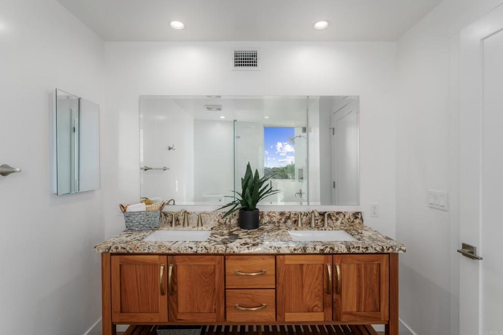 2648 State Street, Unit E Carlsbad, CA 92008 - Photo 15 of 24 a bathroom with a granite countertop sink and a mirror