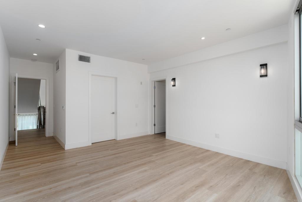 2648 State Street, Unit E Carlsbad, CA 92008 - Photo 10 of 24 a view of an empty room with wooden floor and a bathroom