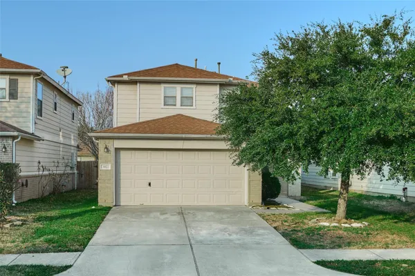 a front view of a house with a yard and trees