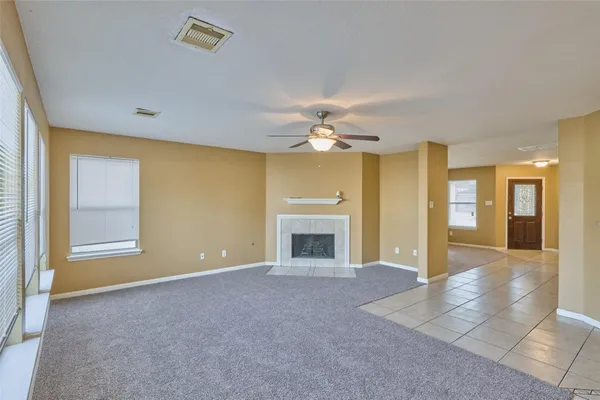 a view of livingroom with an empty room and chandelier fan
