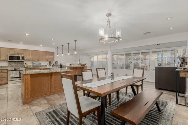 a kitchen with a dining table chairs and wooden floor