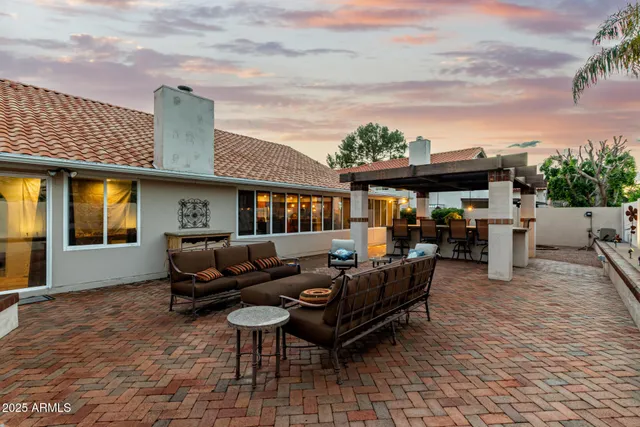 a backyard of a house with table and chairs
