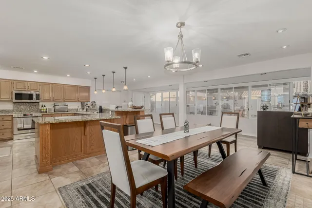 a kitchen with a dining table chairs and wooden floor
