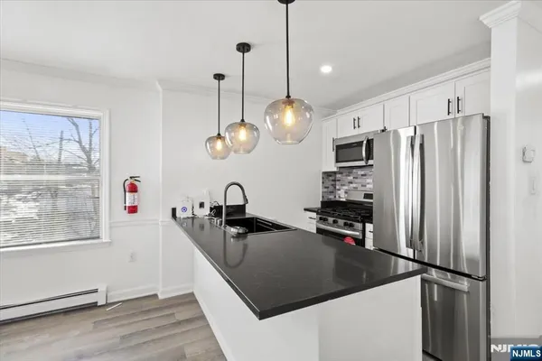 a kitchen with kitchen island a counter top space appliances and a sink