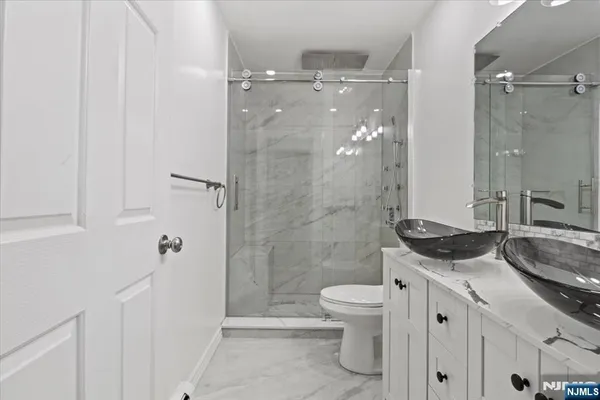 a bathroom with a sink a toilet and shower