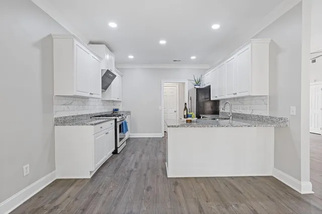 an empty room with wooden floor chandelier fan and windows