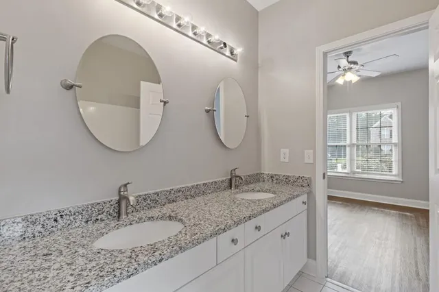 a bathroom with a sink double vanity granite tub and shower