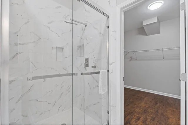 a bathroom with a granite countertop sink and mirror with shower