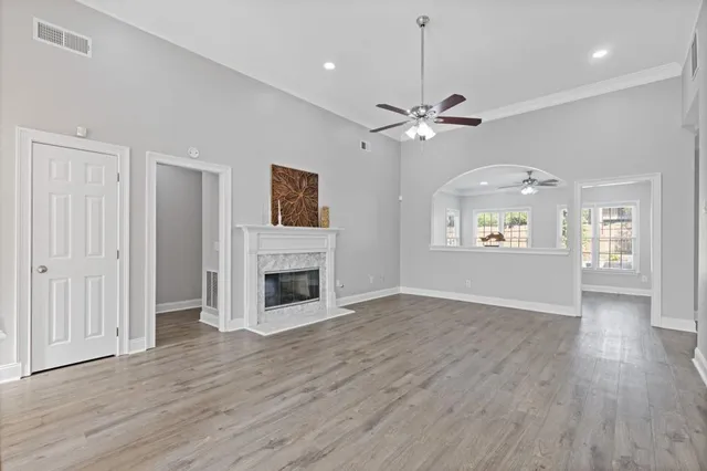 a living room with furniture a fireplace and a ceiling fan