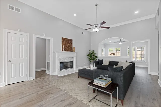 an empty room with wooden floor fireplace and windows