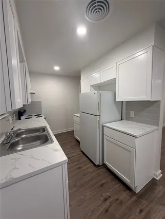 a kitchen with sink a refrigerator and cabinets