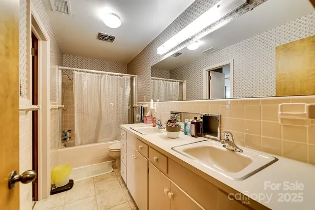 a bathroom with a sink double vanity mirror and a bathtub