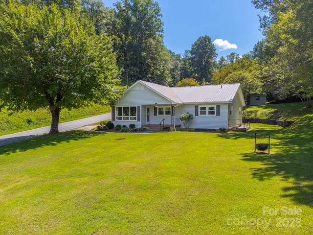 a front view of house with swimming pool and green space