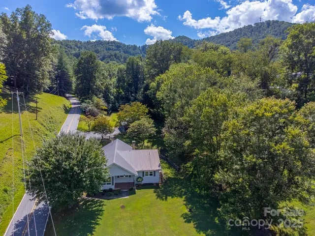 a view of a house with a swimming pool a patio and yard