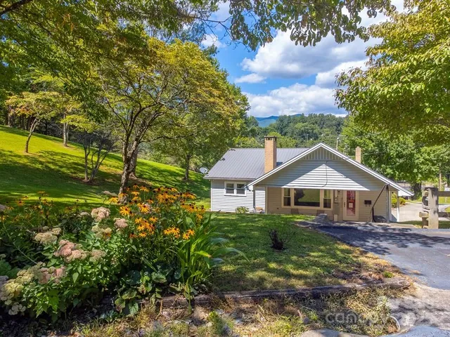 a house with green field in front of it