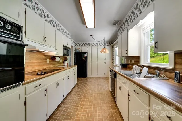 a large kitchen with stainless steel appliances kitchen island granite countertop a sink and cabinets